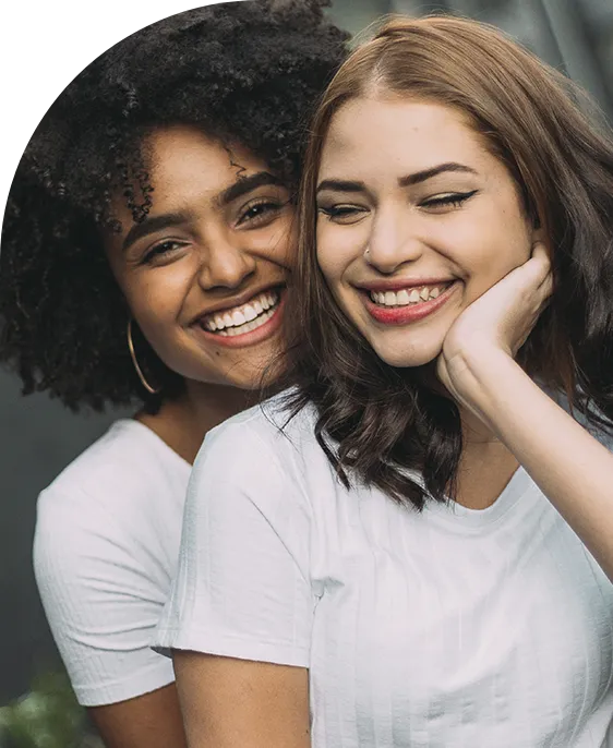 Chicas sonriendo después de recibir una ortodoncia convencional autoligada en Clínicas Sanium