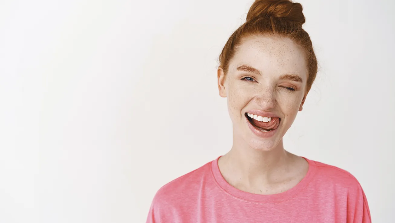 Chica sonriendo después de un tratamiento contra la gingivitis en Clínicas Sanium